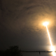 A photo of a SpaceX rocket launching through the clouds at night.